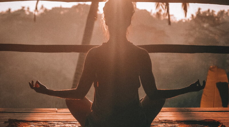 Γυναίκα σε στάση πόζας yoga στον ήλιο