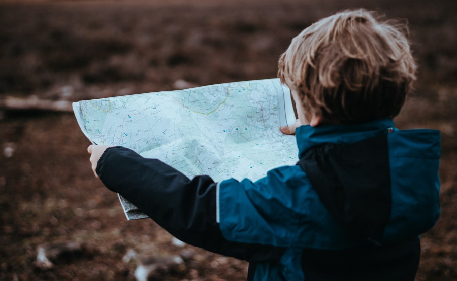 Παιδί με μπουφάν κρατάει έναν χάρτινο χάρτη