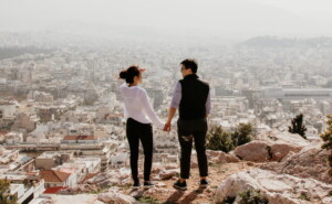 Γυναίκα και άντρας κρατιούνται χέρι-χέρι με θέα μια πόλη
