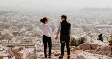 Γυναίκα και άντρας κρατιούνται χέρι-χέρι με θέα μια πόλη